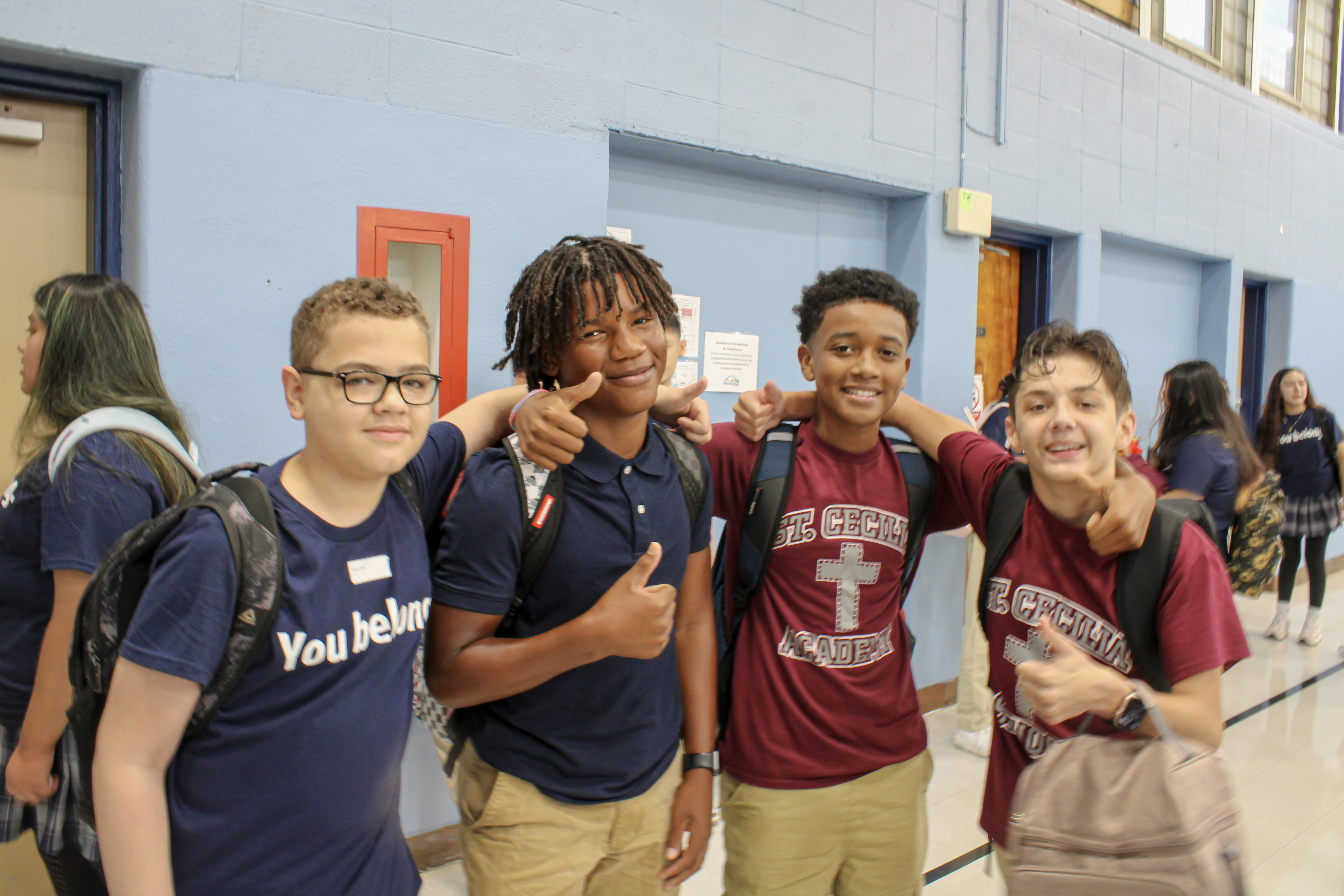 Four high school students with arms on shoulders