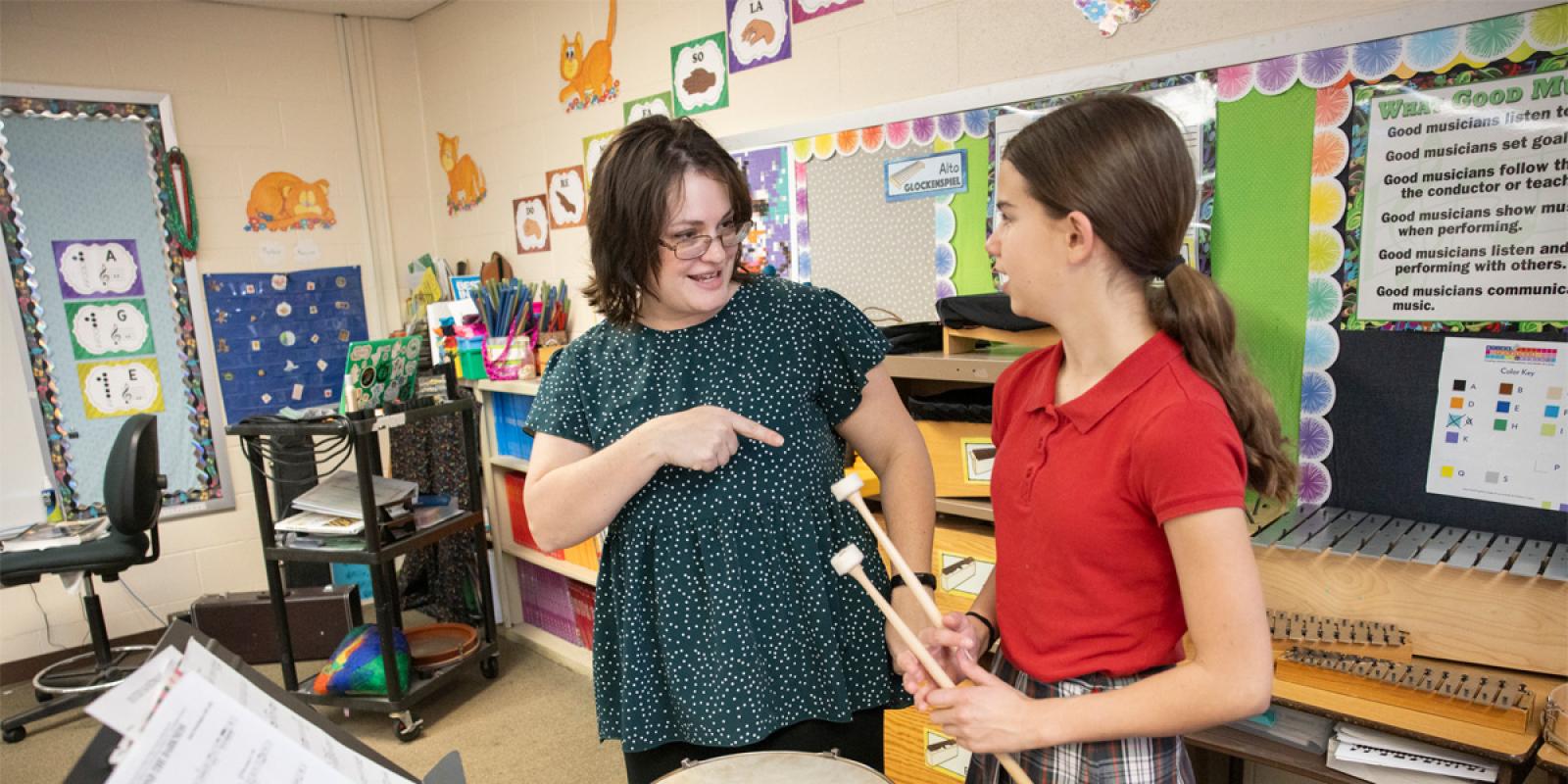 Photos by Jacob Wiegand, jacobwiegand@archstl.org) Music teacher Sam Kaatmann worked with eighth grader Amelia Goughenour during a seventh and eighth grade band rehearsal March 30 at Sts. Joachim and Ann School in St. Charles. Kaatmann will be participating in an upcoming Extra Credit program at Powell Hall performing with musicians from the St. Louis Symphony Orchestra.