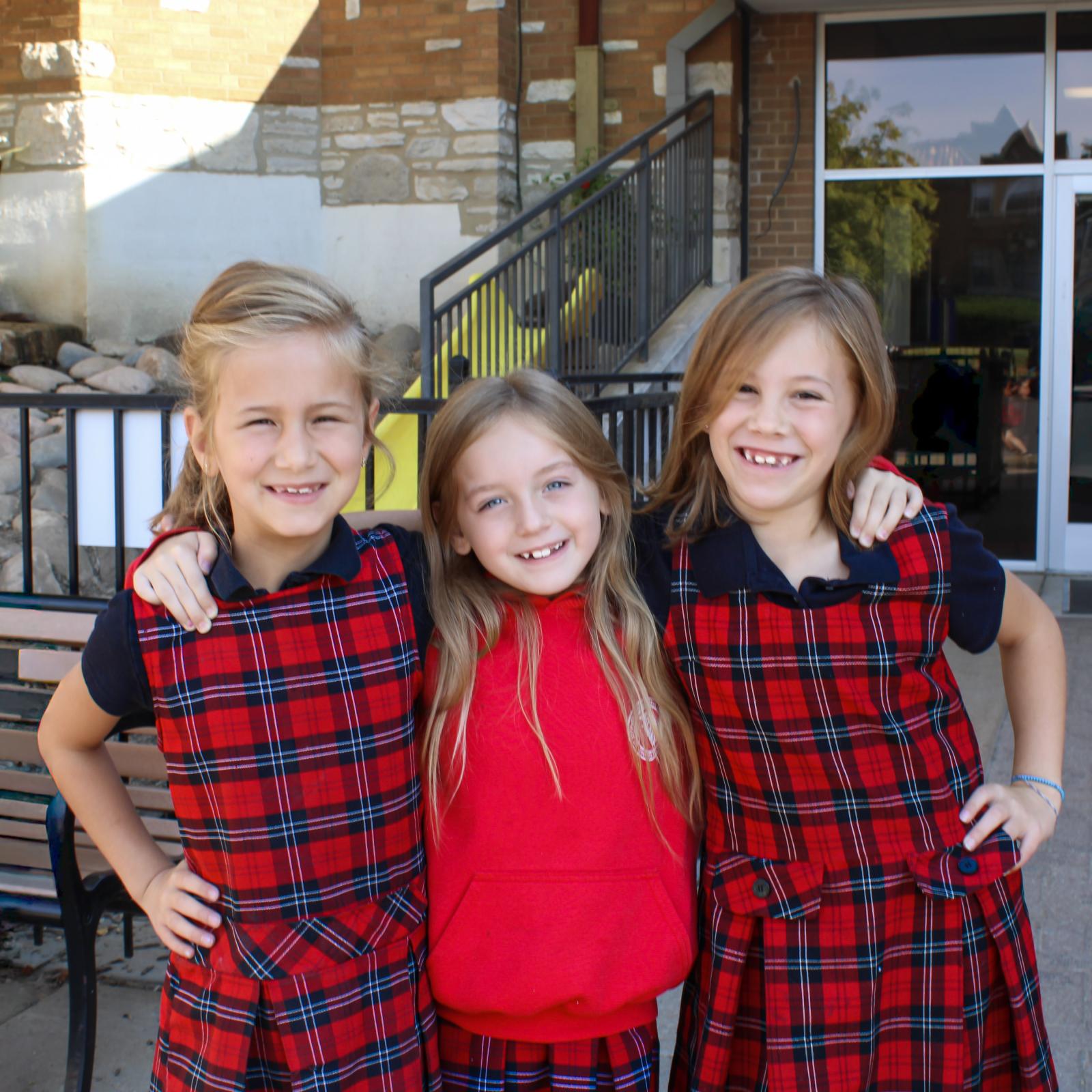 Three young students embraced and smiling