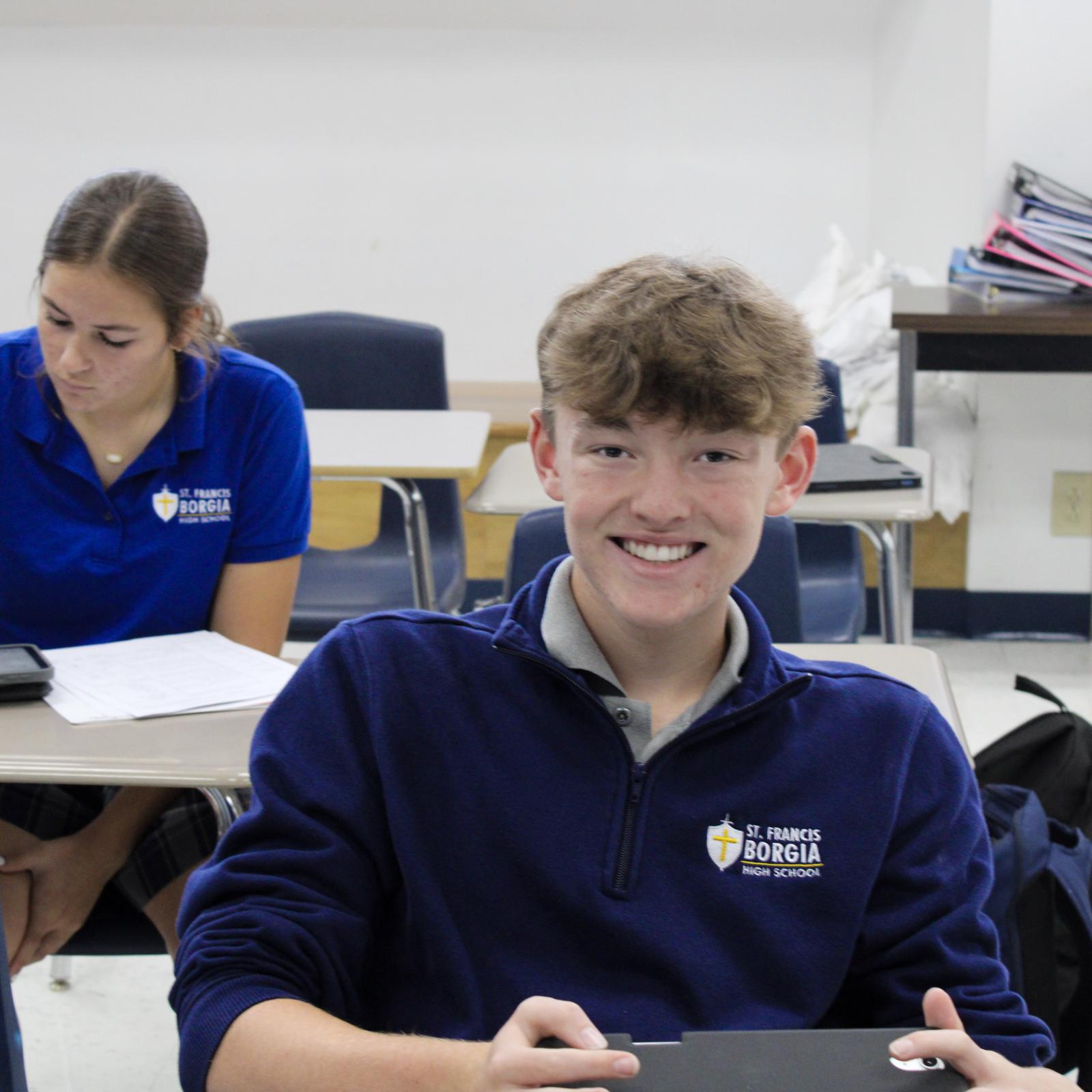 High school student seated, smiling